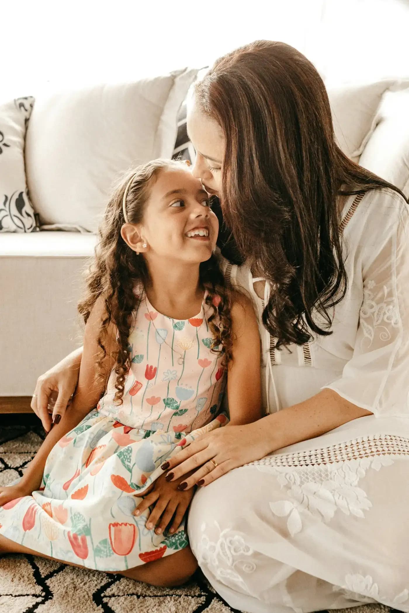 Une mère et sa fille assises sur un tapis