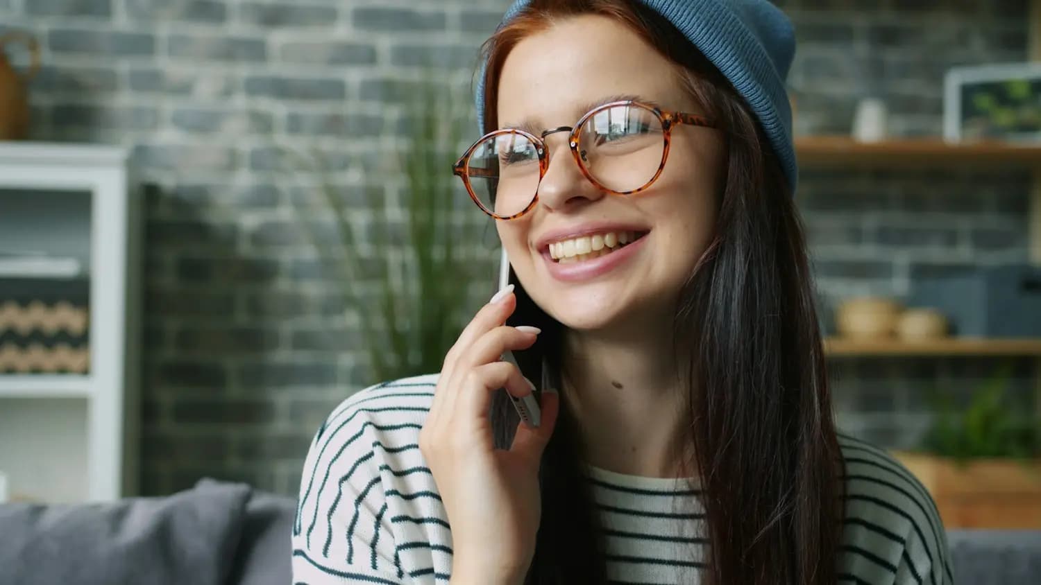 Une jeune femme sourit au téléphone