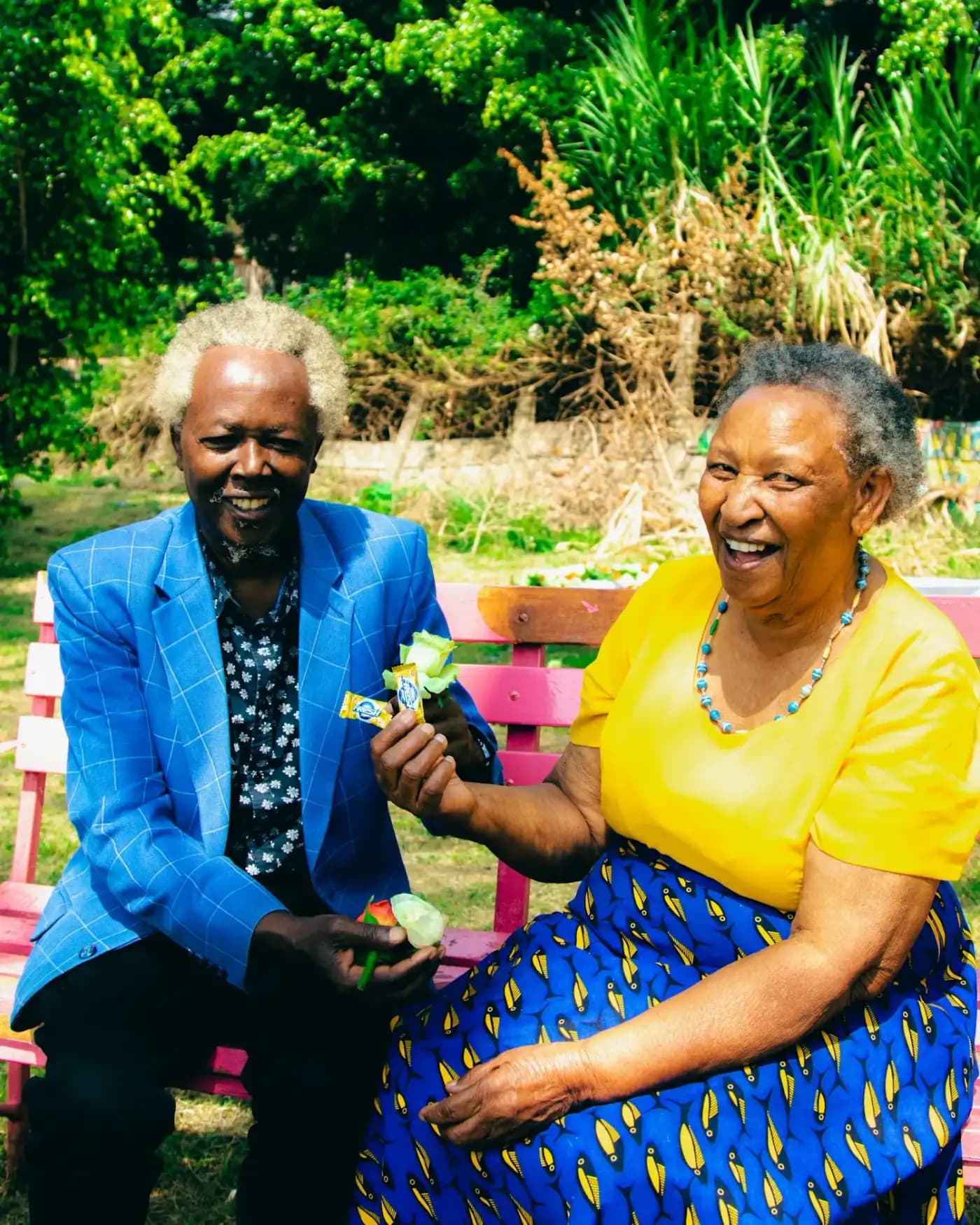 Un couple de grands-parents rit sur un banc