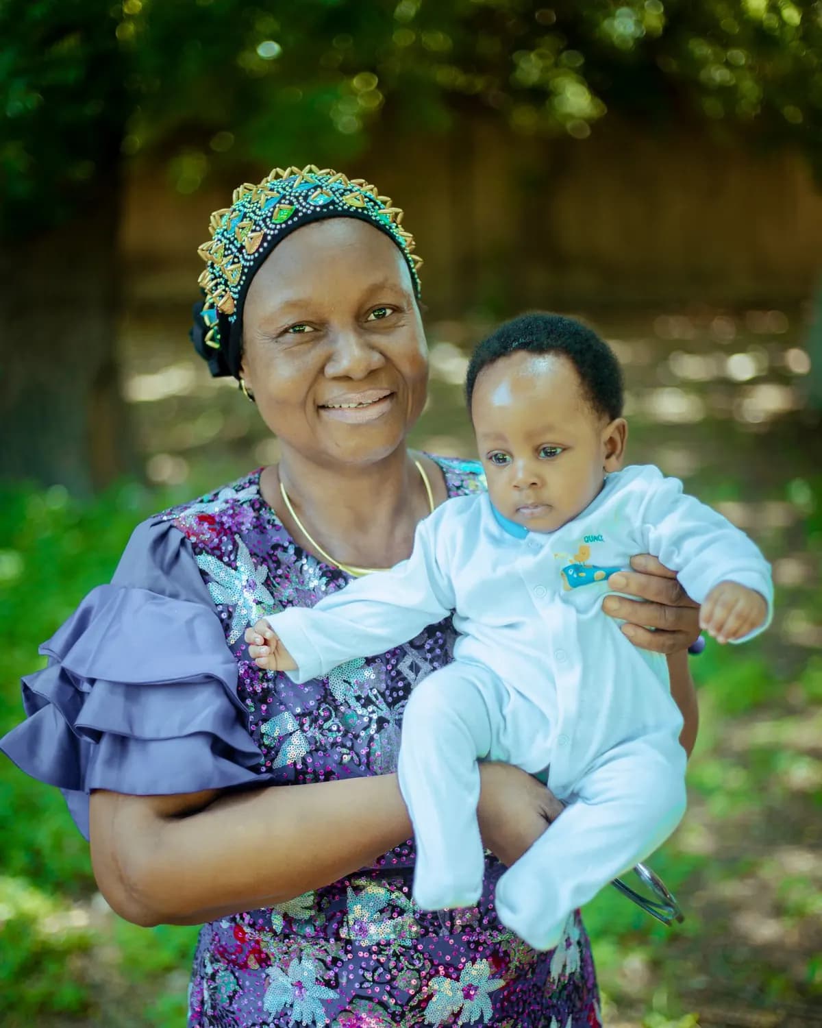 Une grand-mère souriante porte un bébé dans ses bras