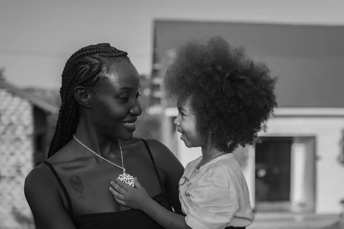 Une mère sourit à sa petite fille qu’elle tient dans ses bras