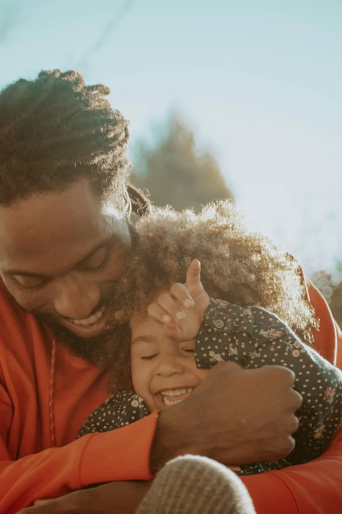 A father hugs his laughing daughter