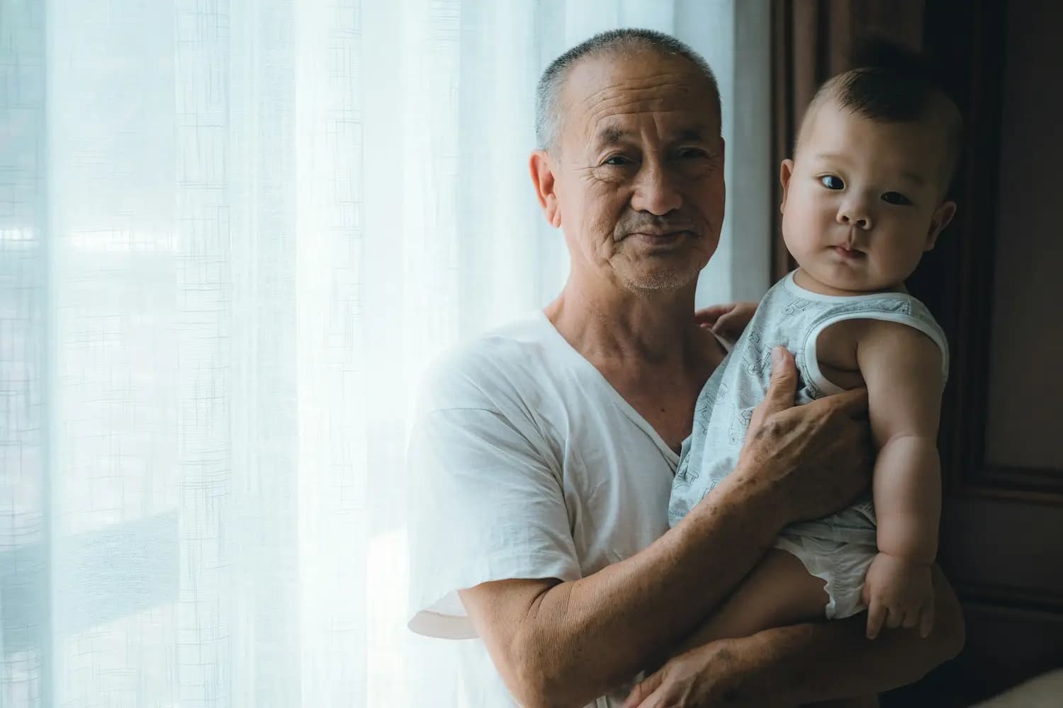 Un grand-père porte un bébé