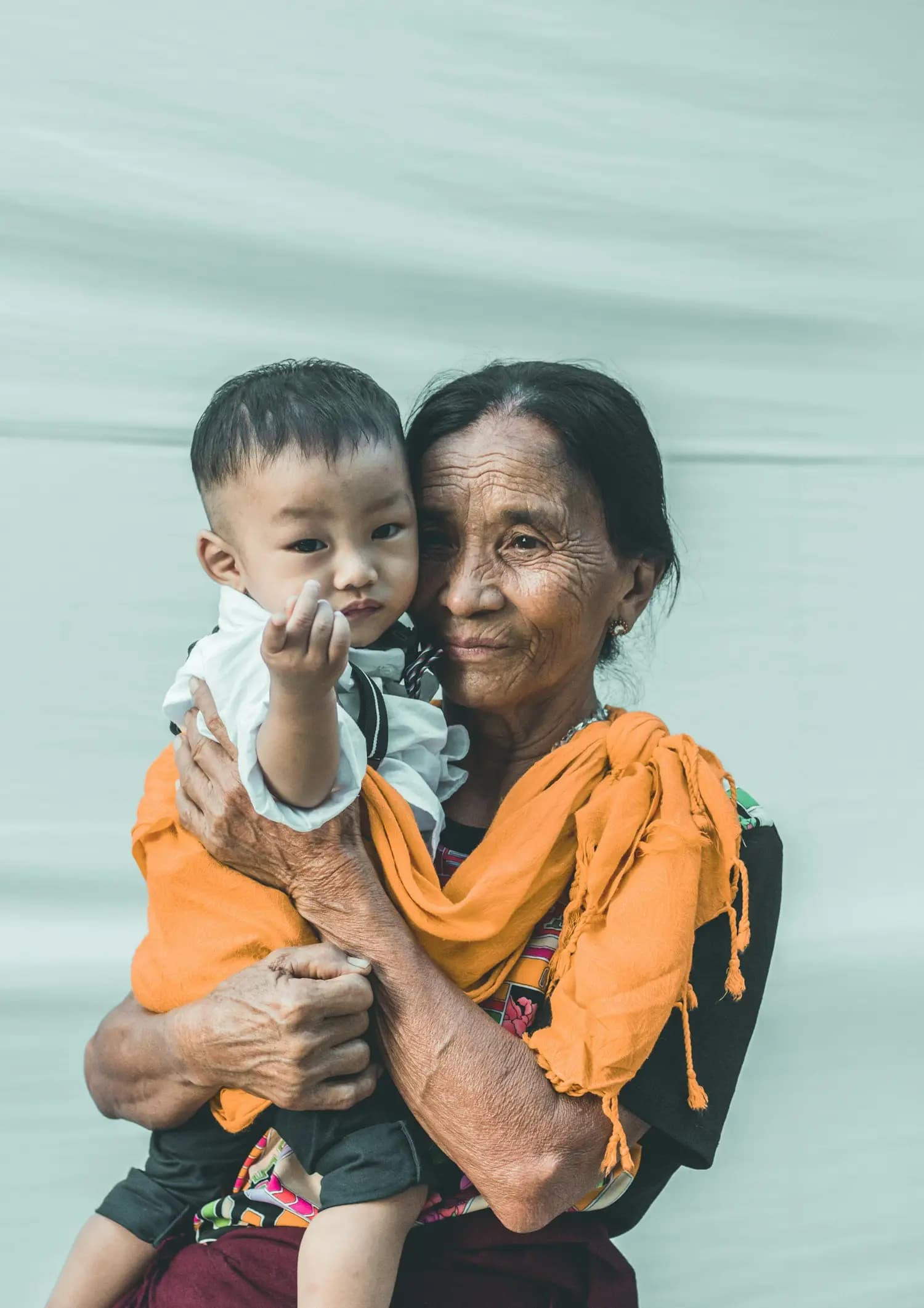 A grandmother holds her grandson in her arms