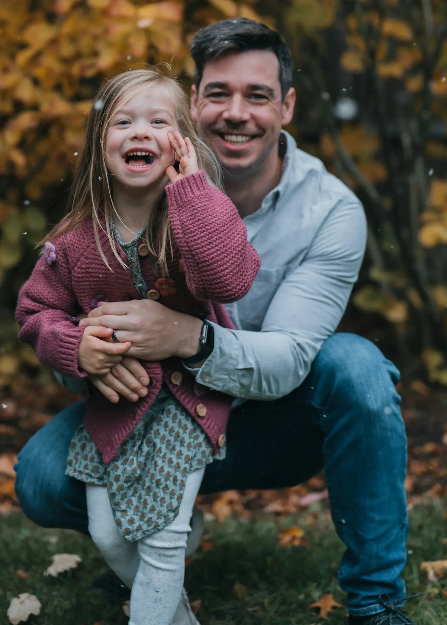 A father and his daughter laughing in autumn