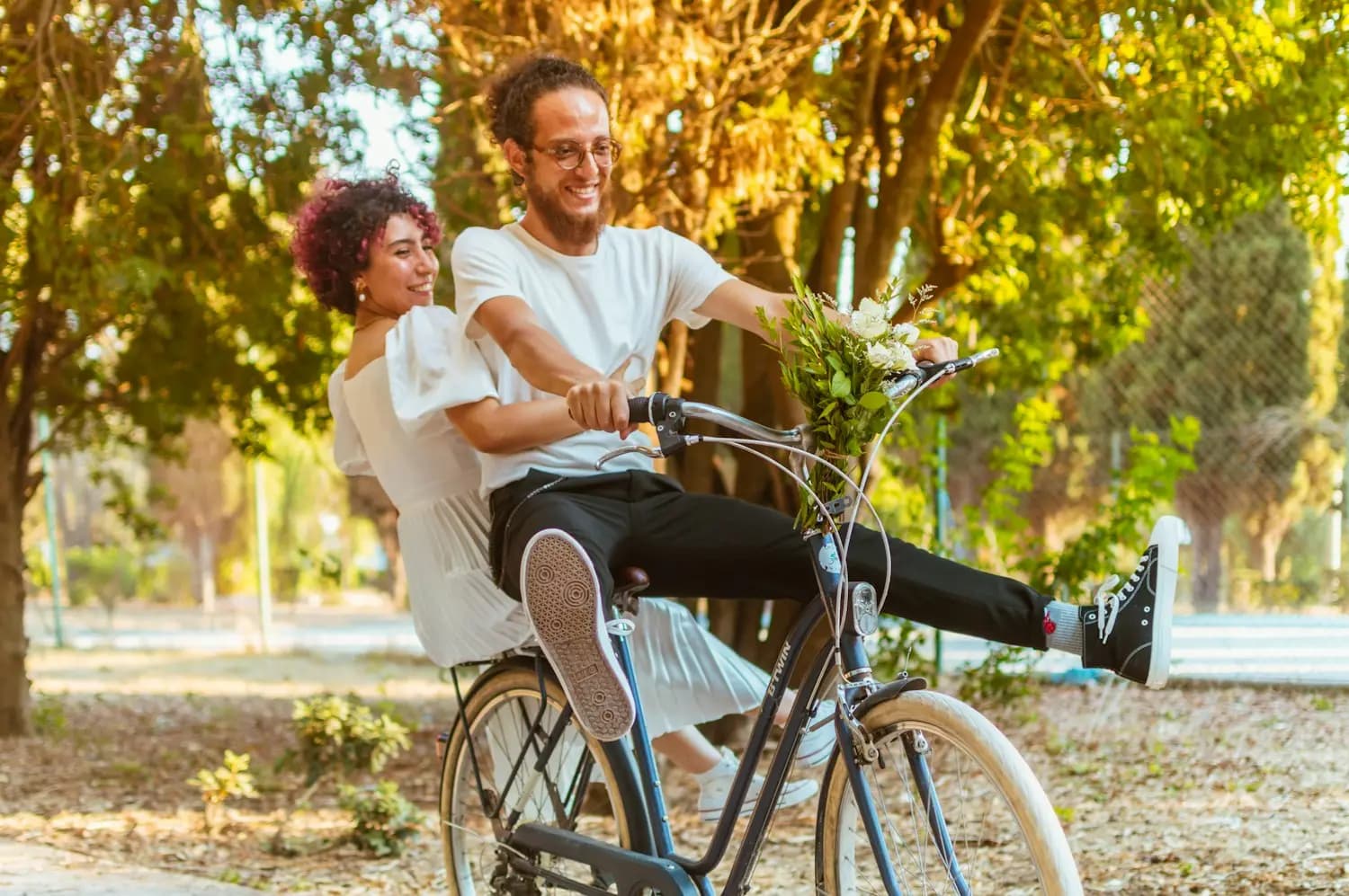 Un couple rit en faisant du vélo