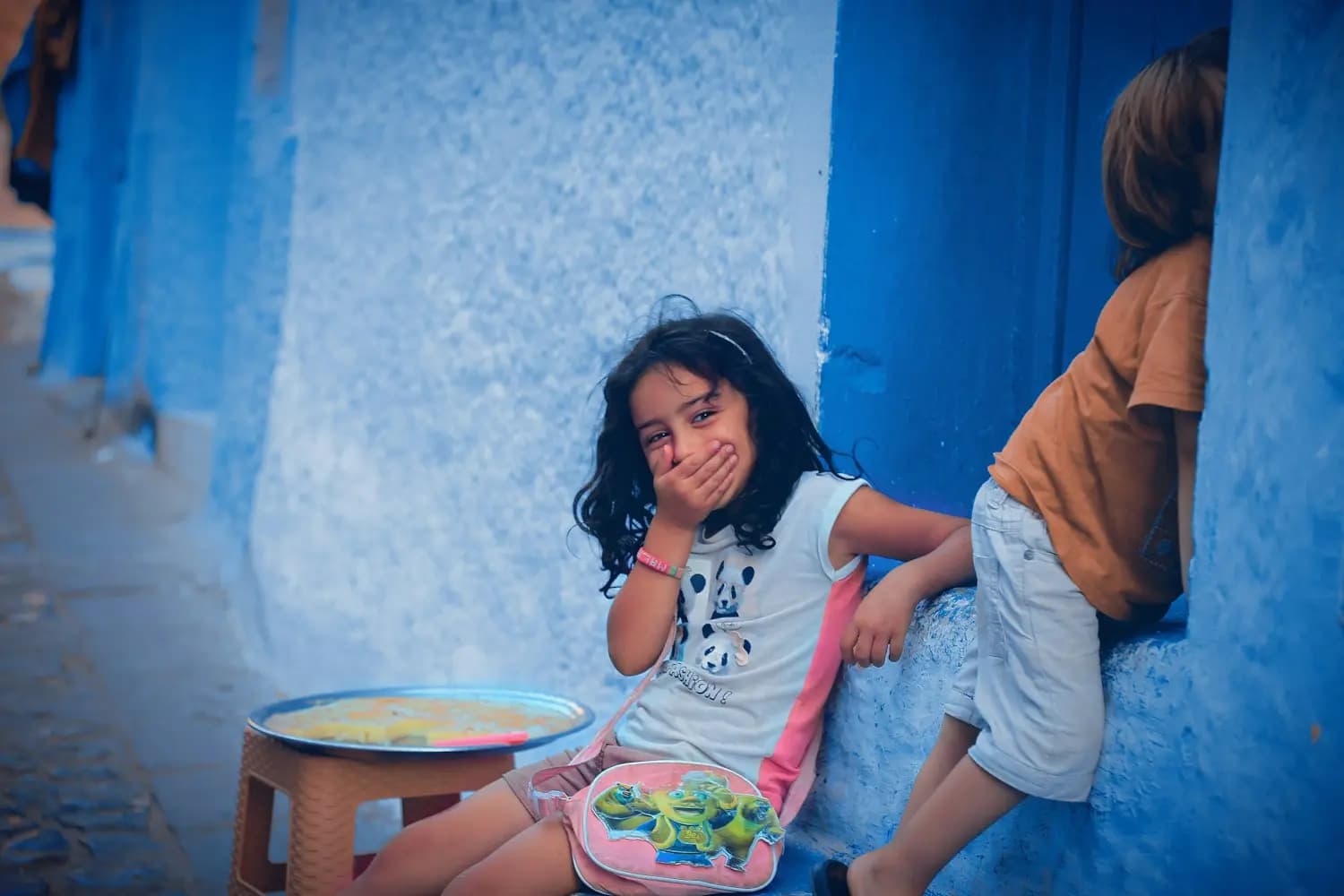 Deux enfants devant un mur bleu