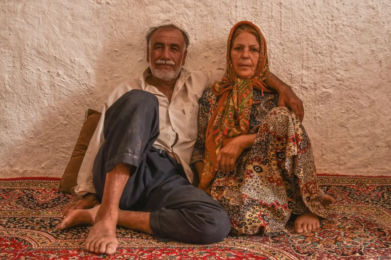 A grandparent couple sitting on a rug