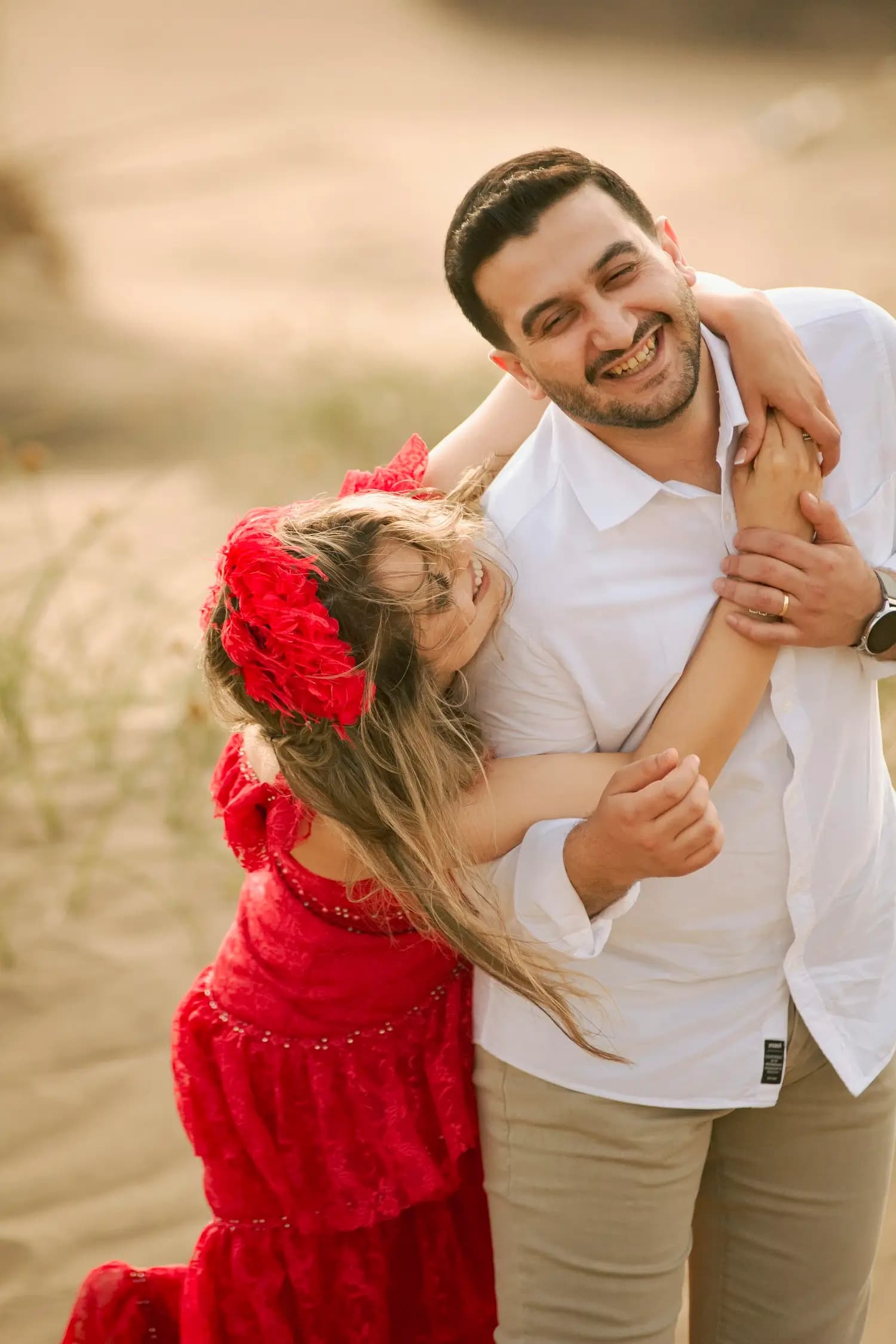 A father laughing with his daughter in his arms